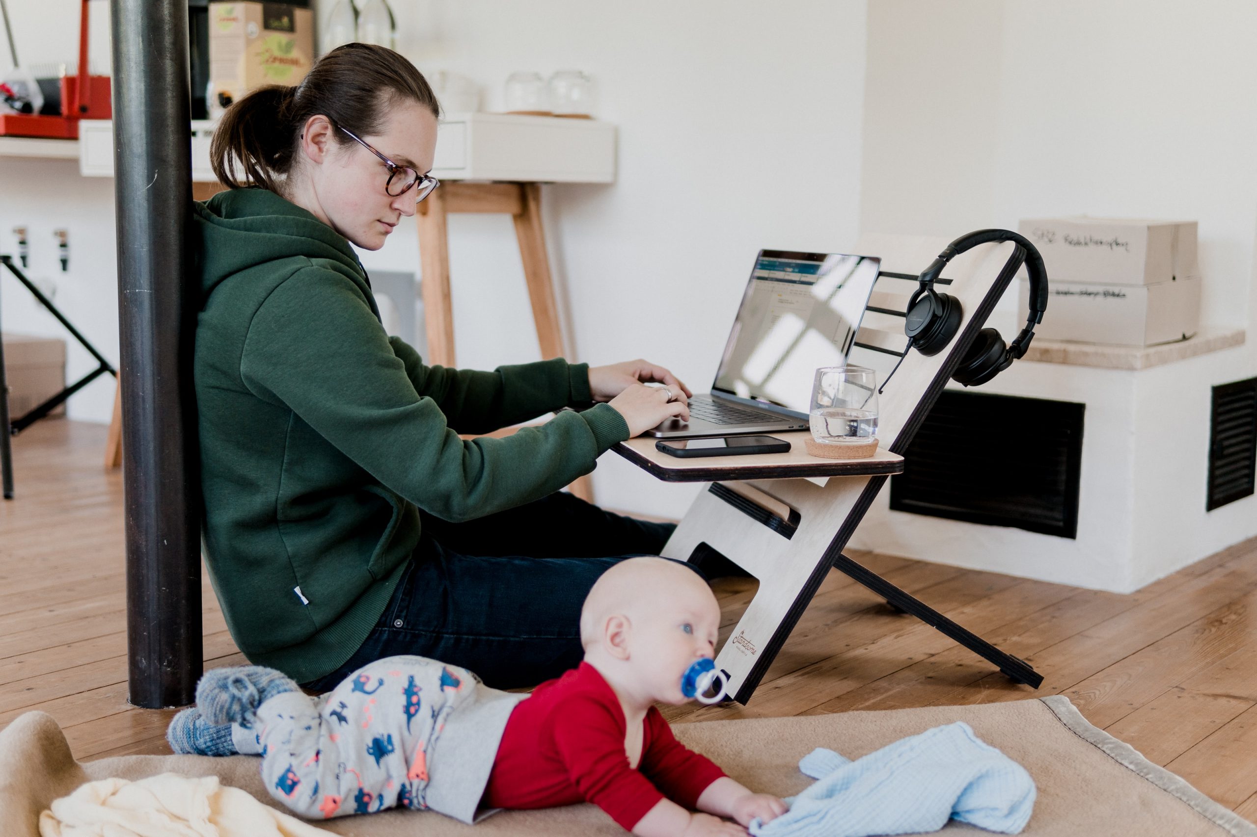 woman in green sweater sitting on chair while holding baby